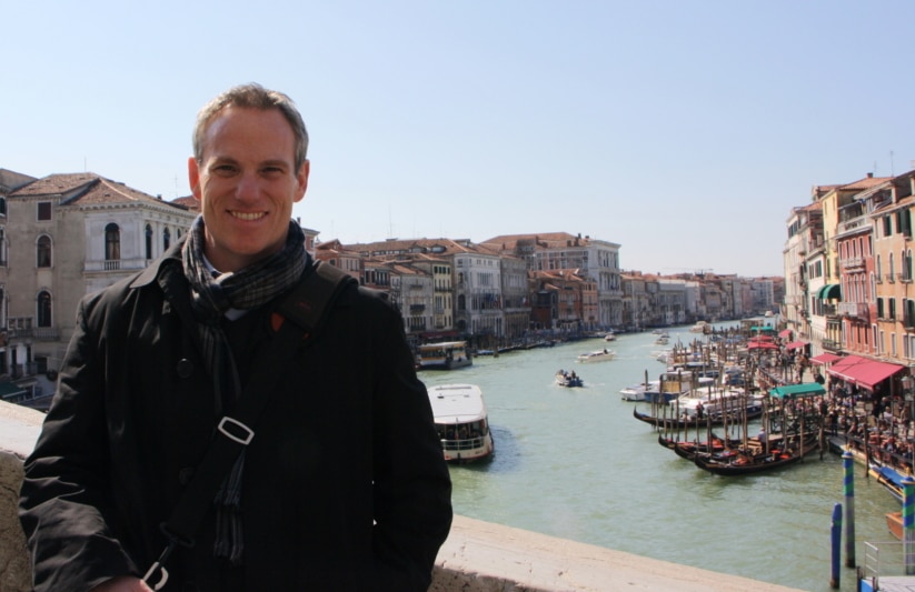 Teacher on the Rialto bridge in venice with the grand canal in the background