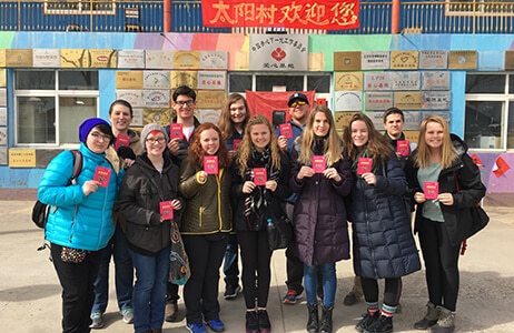 ACIS group standing in front of a school in Beijing