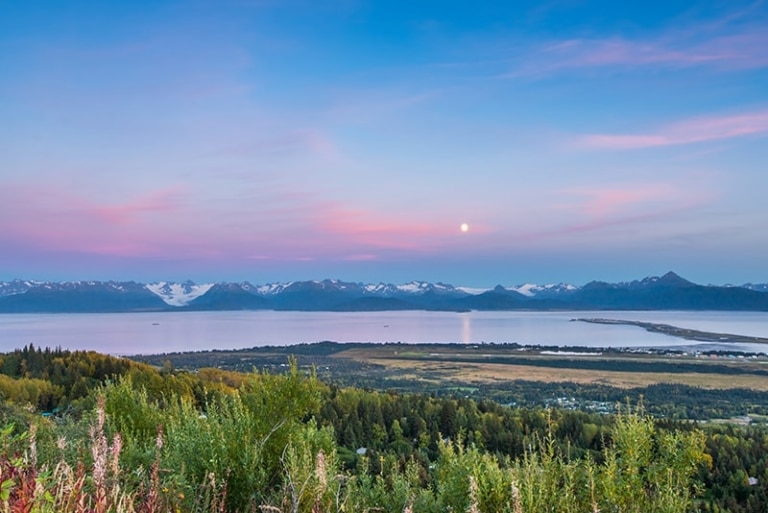 Alaska landscape with mountains, water and pink clouds