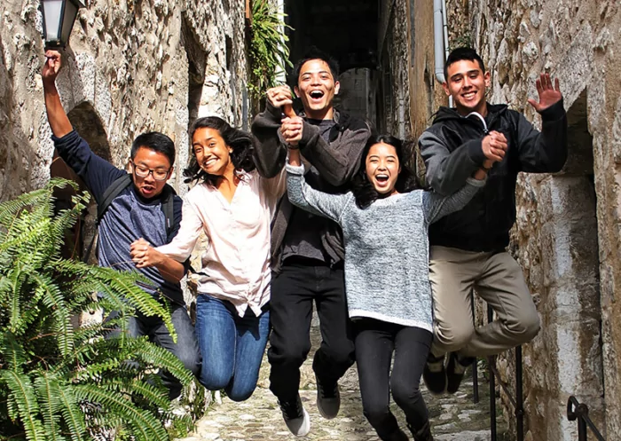 Students excitedly jumping through stone walkway