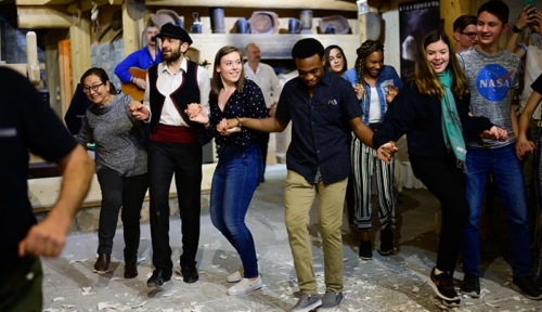 Greek cultural evening and dance lesson group of students dancing with host