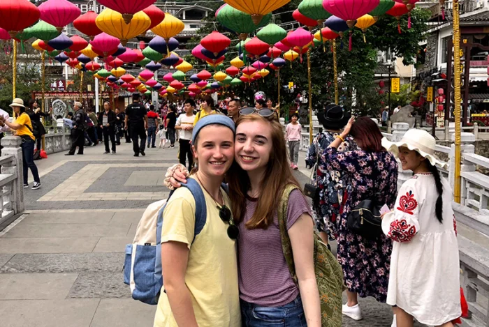 Two students take a photo under colorful lanterns in China