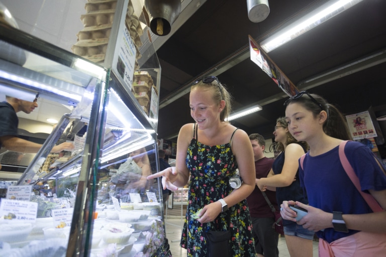 Two girls looking at food options at an indoor market