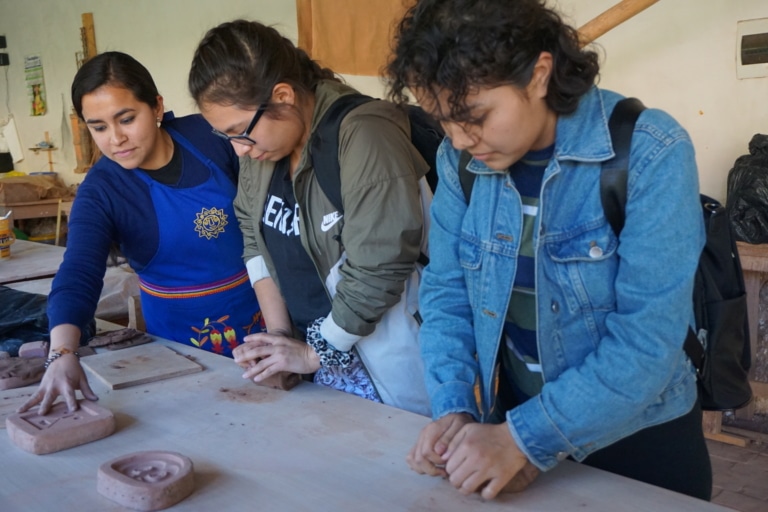Students kneading clay at a cultural connection