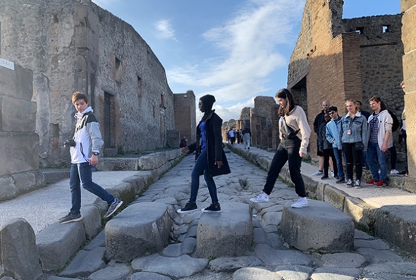 Students walking on ancient crosswalk in Pompeii