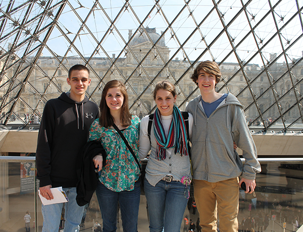 Students pose in the glass pyramid at the Louvre