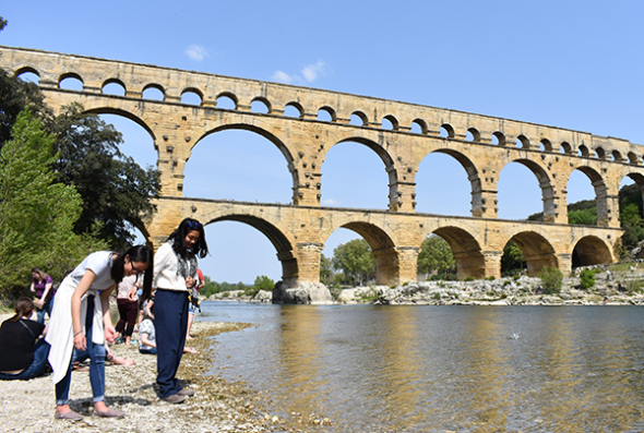 Students skipping rocks near Pond du Gard in France
