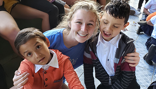 Girl poses with local school children