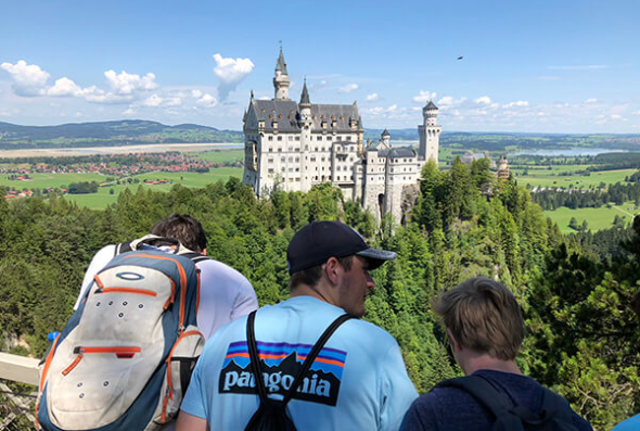 Students and Neuschwanstein castle in the distance
