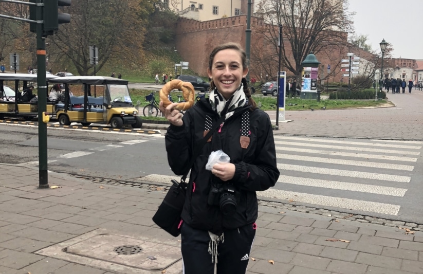 young lady holding a pastry during a trip