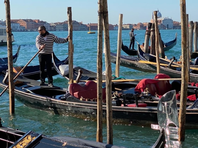Gondolas and  gondoliers at their moorings
