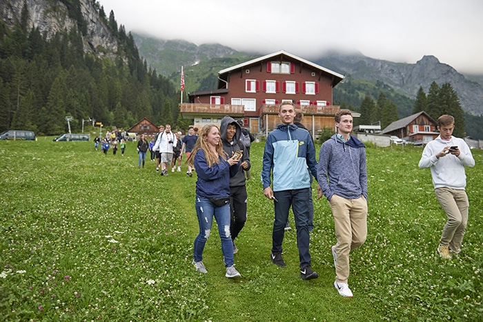 Students walk through a meadow in Engelberg