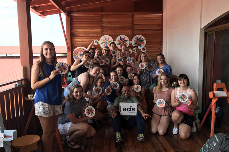 Student group pose with their painted Sarchi souvenirs