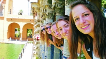 Students peeking out from pillars in Seville
