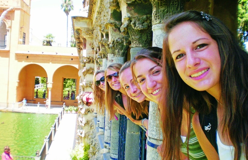 Students peeking out from pillars in Seville
