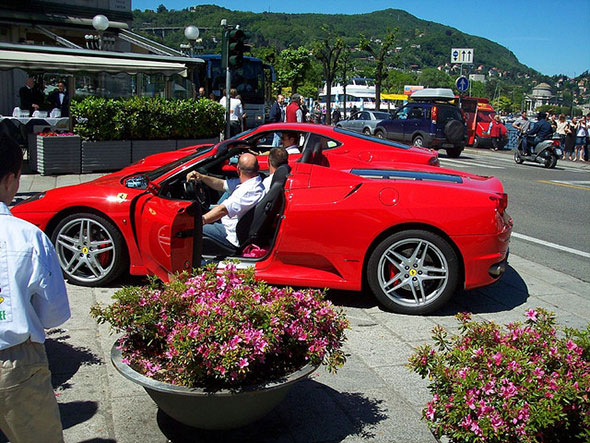 Red ferrari with driver coming out of the car