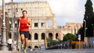 Running runner man by Colosseum, Rome, Italy. Male athlete training for marathon jogging in city of