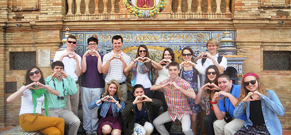 Student group making the heart symbol in front of a museum