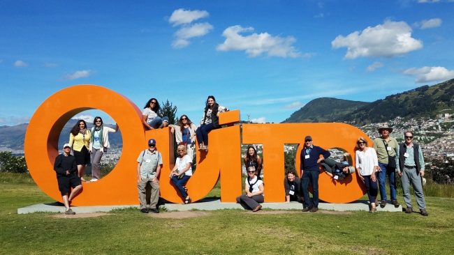 ACIS Group leaders posing with the Quito sign in Ecuador